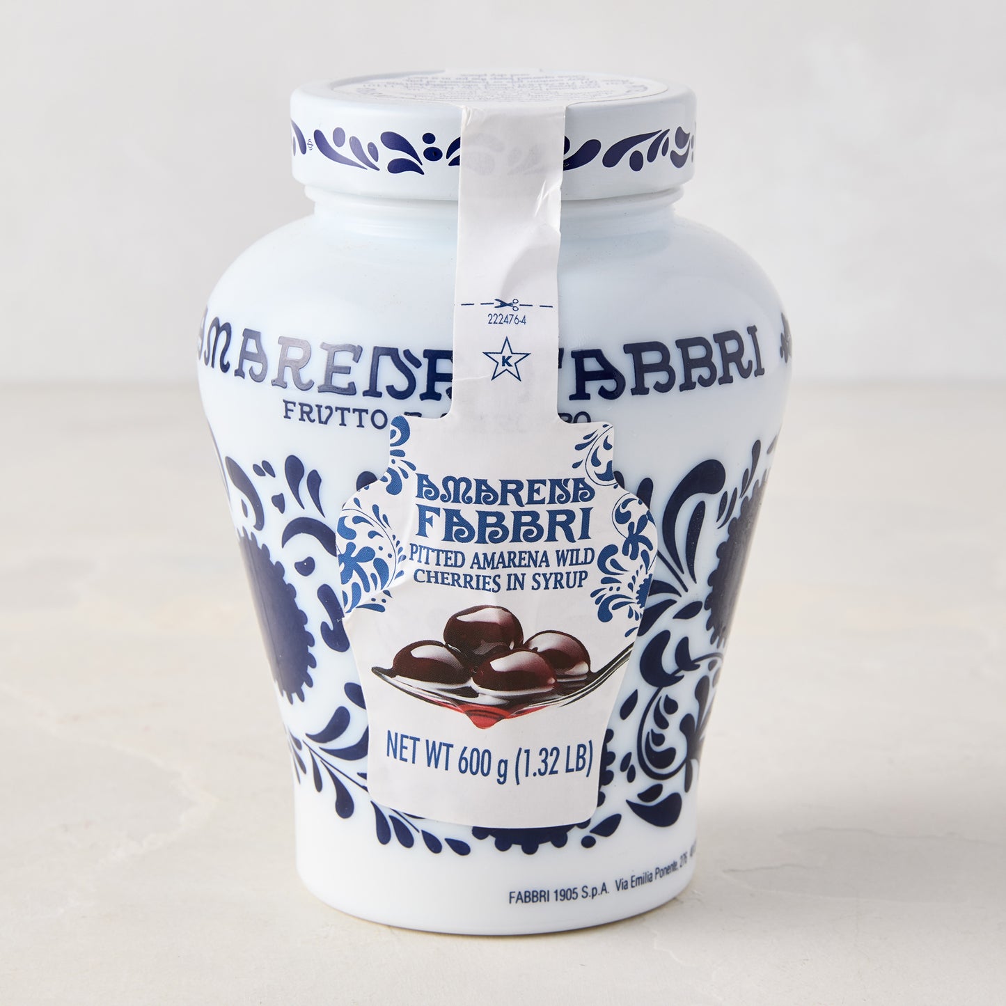 White ceramic Fabbri Amarena cherries jar with blue floral design and product label.