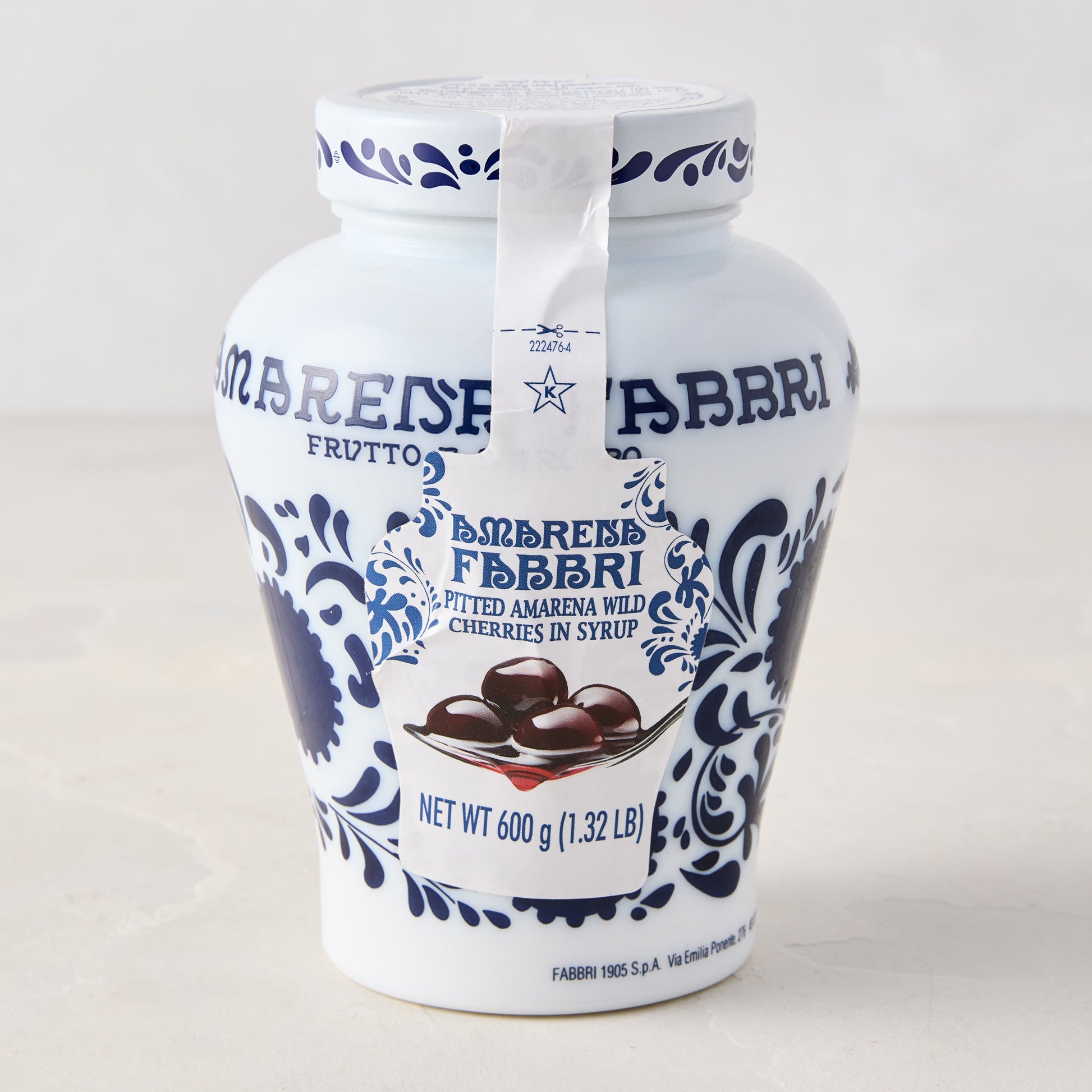 White ceramic Fabbri Amarena cherries jar with blue floral design and product label.