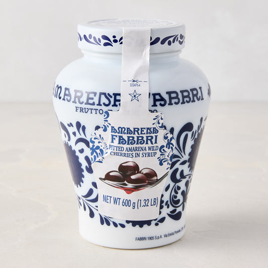 White ceramic Fabbri Amarena cherries jar with blue floral design and product label.