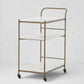 Felix antique brass bar cart with three white marble rectangular shelves on casters.