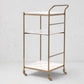 Felix antique brass bar cart with three square white marble shelves and casters.