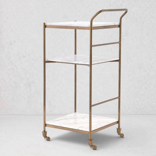 Felix antique brass bar cart with three square white marble shelves and casters.