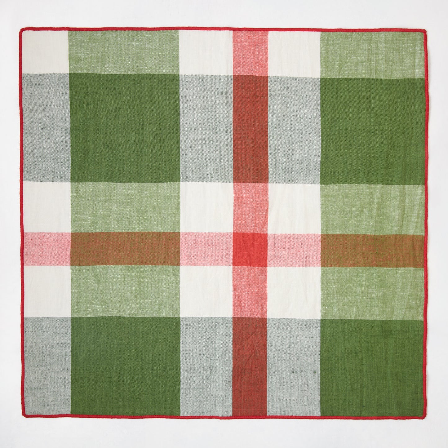 Festive green, red, and white plaid cotton napkin with embroidered red trim, 22" square.