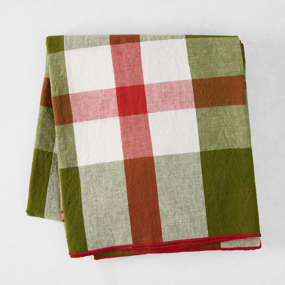 Folded Festive Green and Red Plaid Tablecloth with embroidered red trim, 100% cotton.