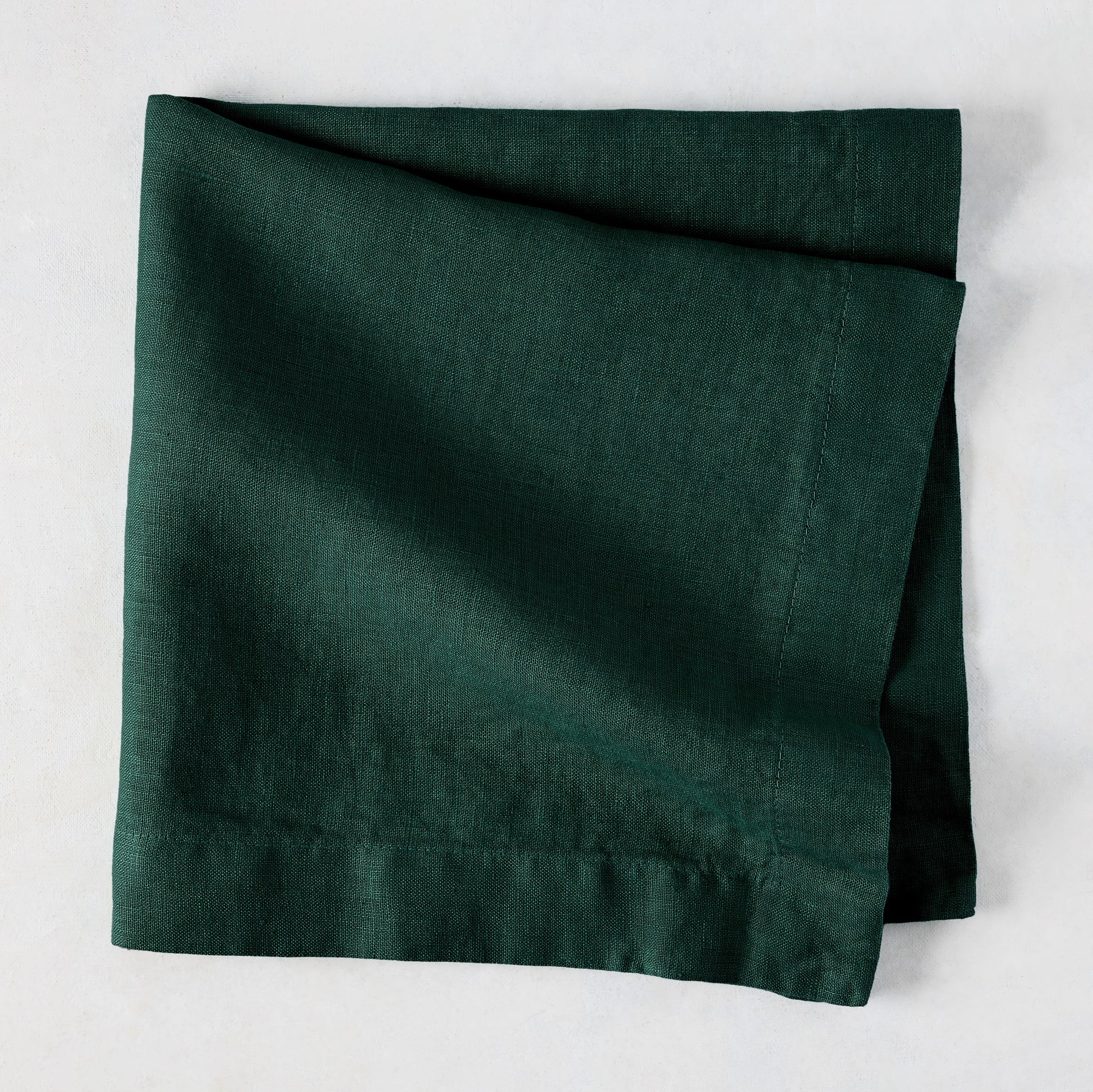 Fir HG Hand-dyed Linen Napkin, dark forest green, folded square, 22-inch, mitered corners.