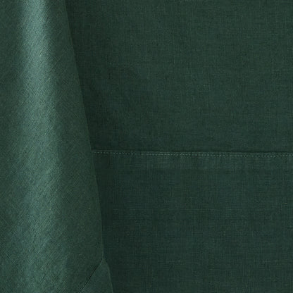 Fir green hand-dyed 100% linen tablecloth with visible fabric texture and a stitched mitered border detail.