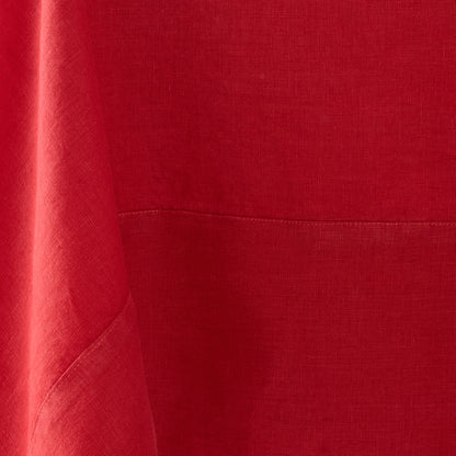 Flame red hand-dyed linen tablecloth with visible fabric texture and a stitched mitered border detail.