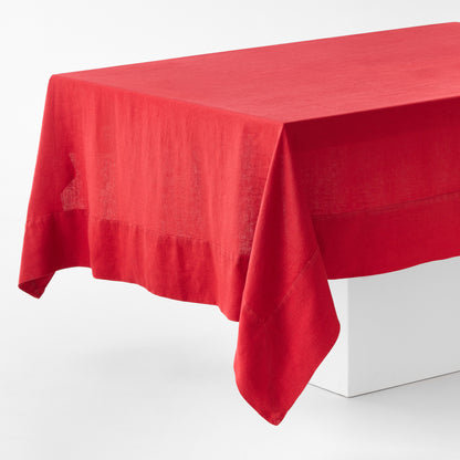 Flame red hand-dyed 100% linen tablecloth with a wide border and mitered corner detailing on a white table.
