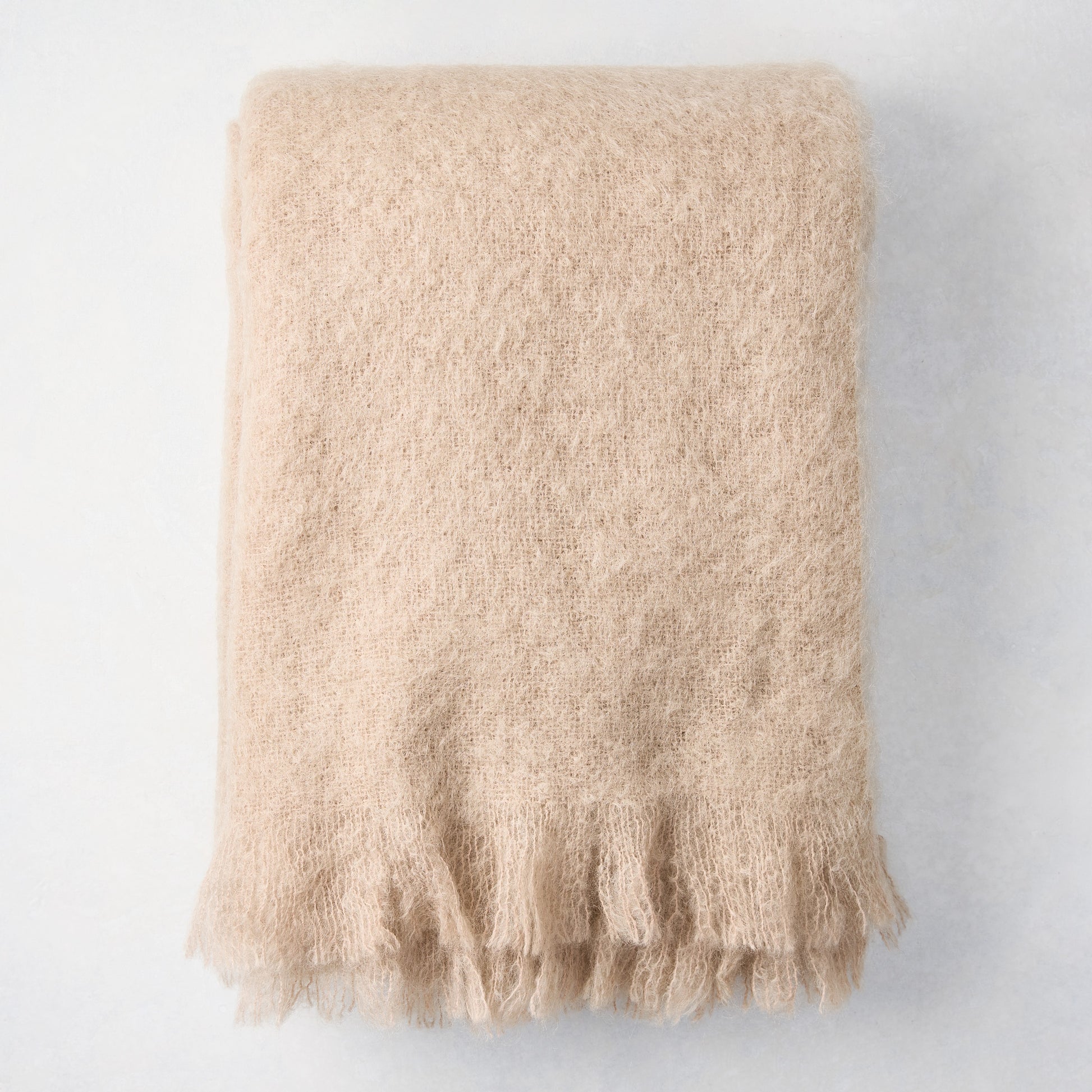 Folded Flax Beige Mohair Throw Blanket, 72"L x 51"W, with fringed edges.