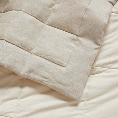 Flax linen quilted coverlet in natural beige, showing a corner fold and textured stitching.
