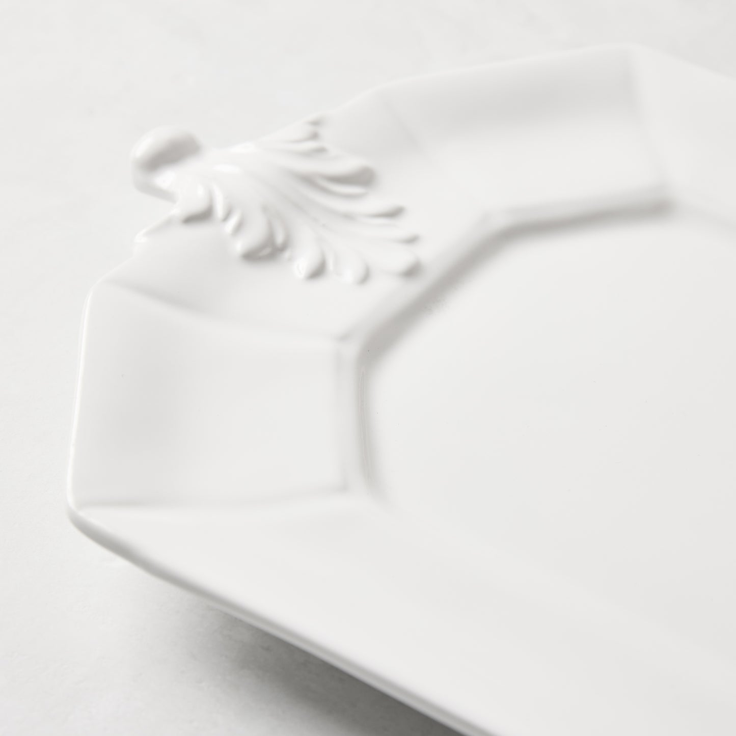 White octagon ceramic serving platter with raised Fleur de Lys detail.