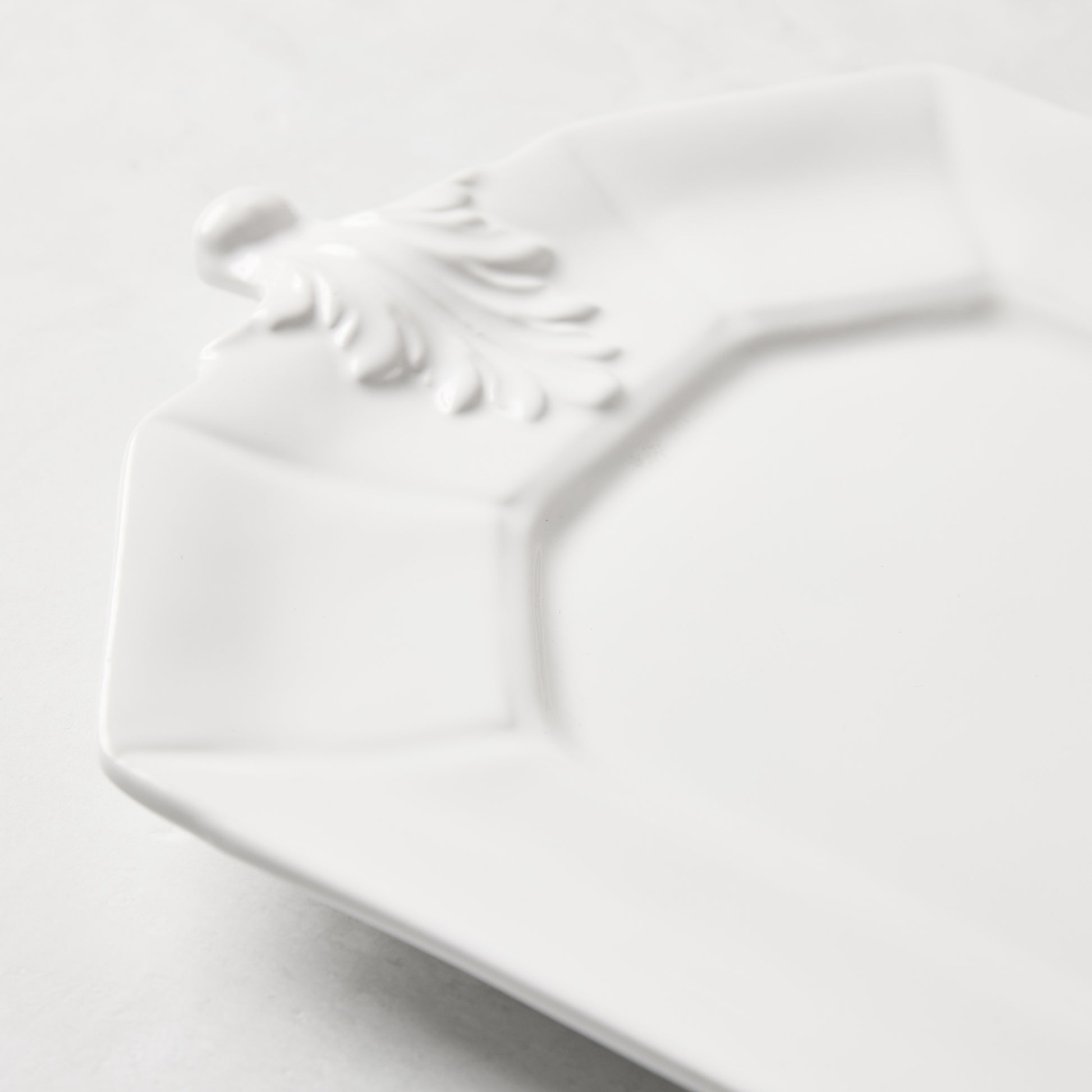 White octagon ceramic serving platter with raised Fleur de Lys detail.