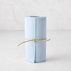 Roll of 50 Foggy Blue tear-off cotton cocktail napkins, tied with natural twine.