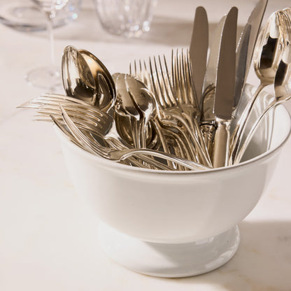 Set of 12 vintage French silver spoons and forks with intricate detailing in a white ceramic bowl.