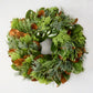 24-inch holiday wreath featuring fresh green magnolia leaves, silver-hued cypress, and golden cedar on a white background.