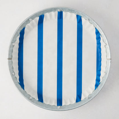 Galvanized metal plate with a white and blue striped parchment liner, top-down view.