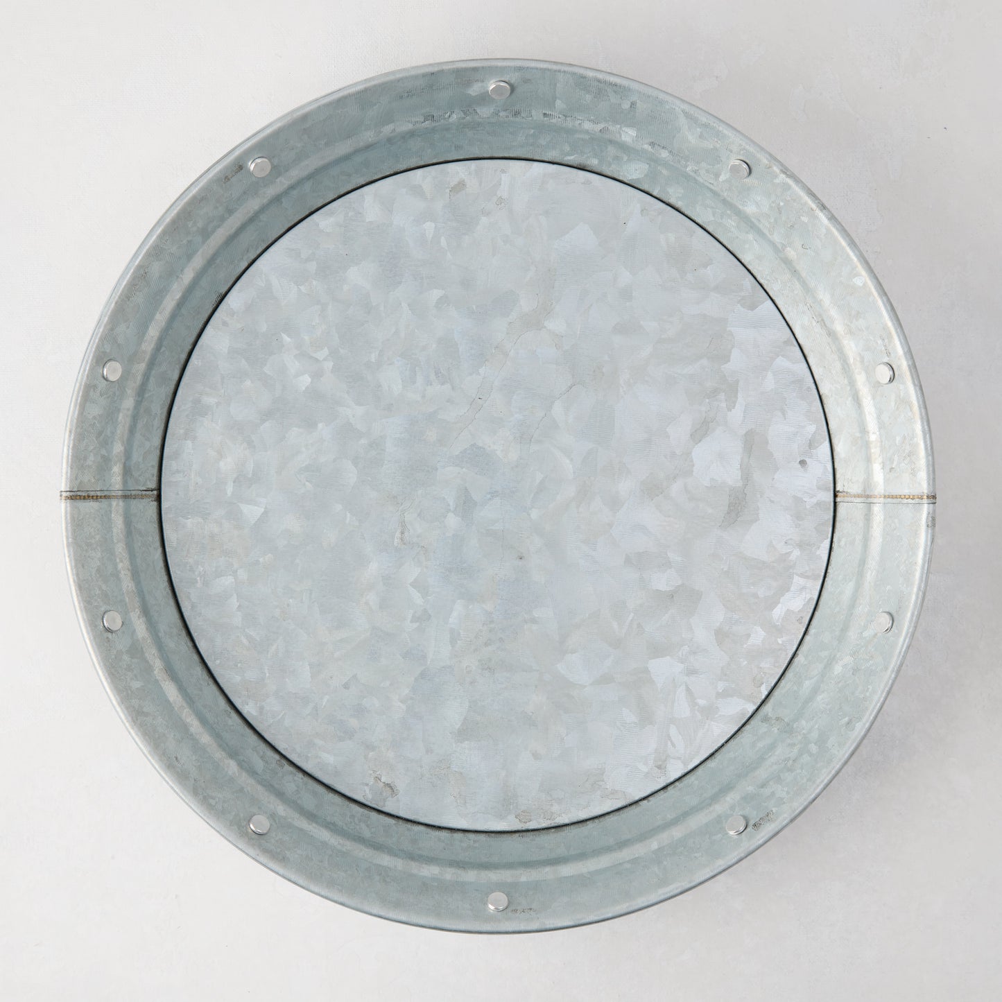 Round galvanized steel plate with a textured, mottled silver finish and riveted rim.