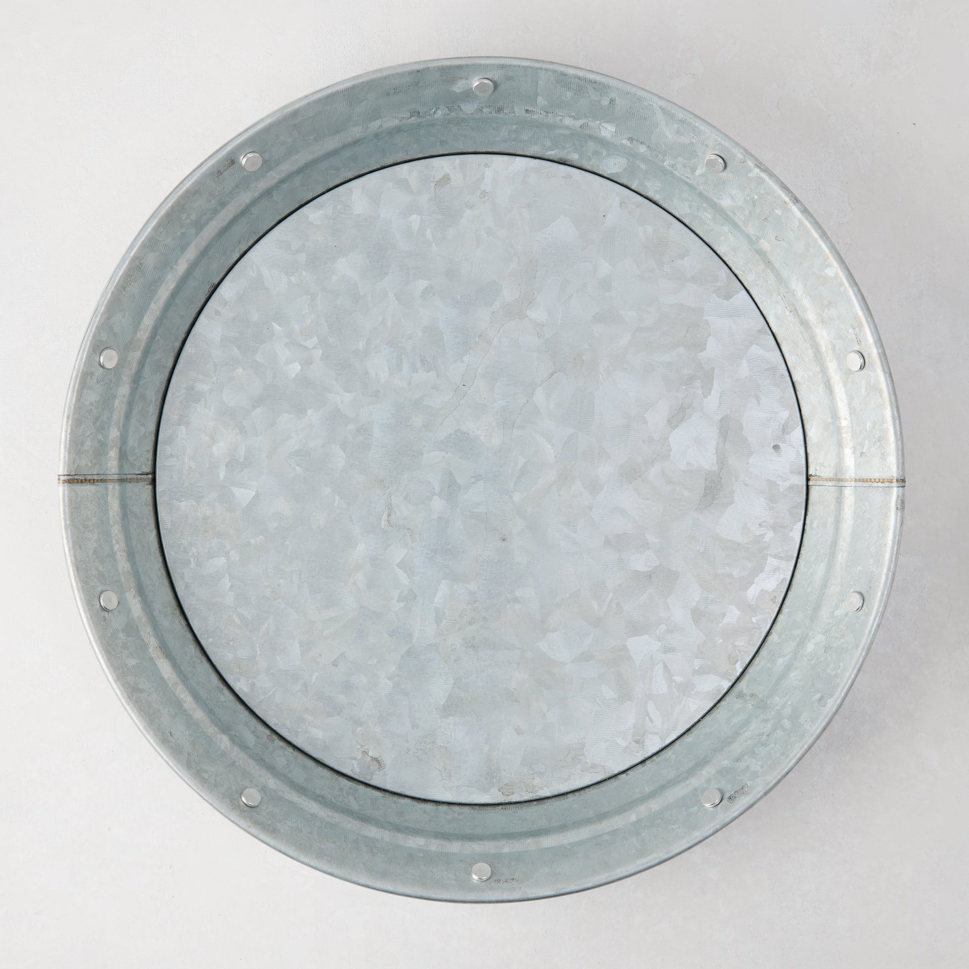 Round galvanized steel plate with a textured, mottled silver finish and riveted rim.