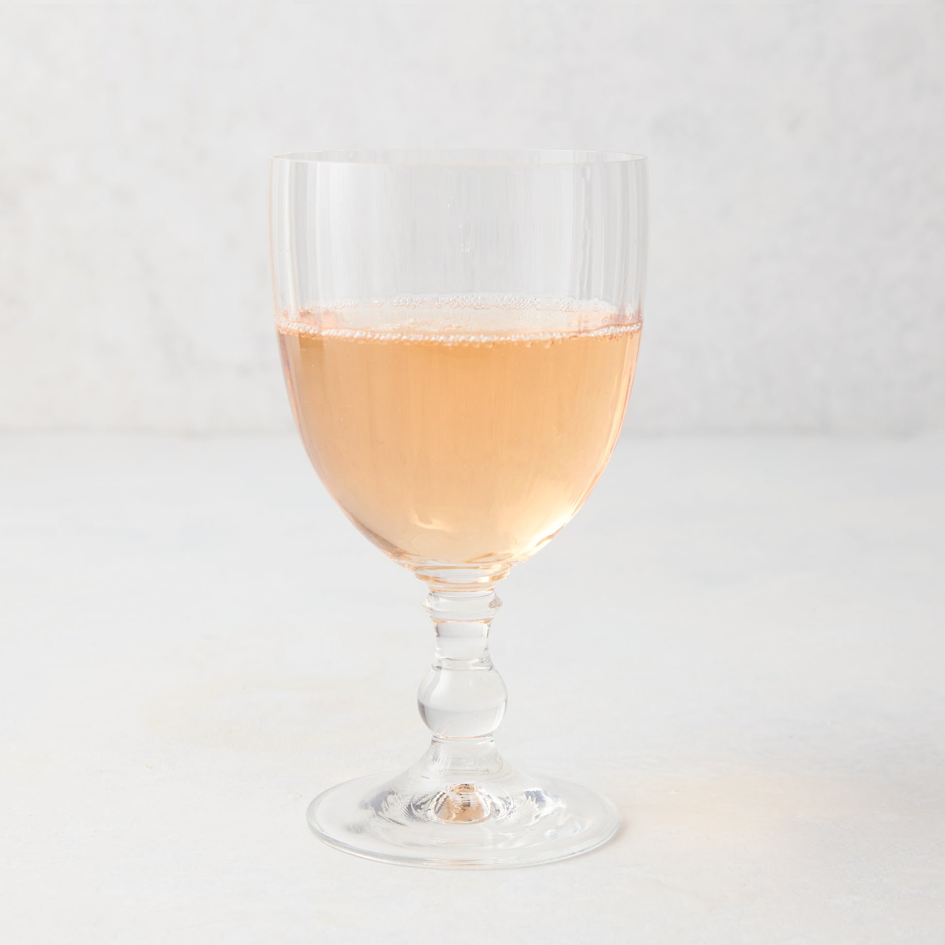 Georgia Eco-Crystal Stemmed Wine Glass, 12oz, with ribbed clear glass and rose wine.