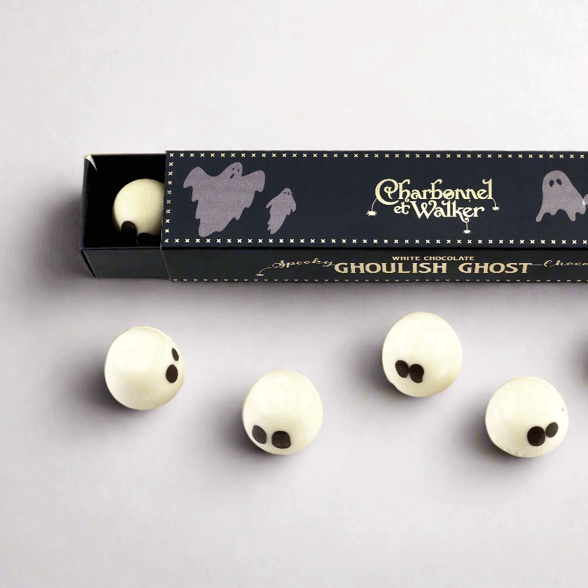 Charbonnel et Walker white chocolate ghost truffles with black eyes, presented in a black Halloween-themed gift box.
