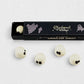 Charbonnel et Walker white chocolate ghost truffles with black eyes, presented in a black Halloween-themed gift box.