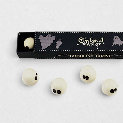 Charbonnel et Walker white chocolate ghost truffles with black eyes, presented in a black Halloween-themed gift box.