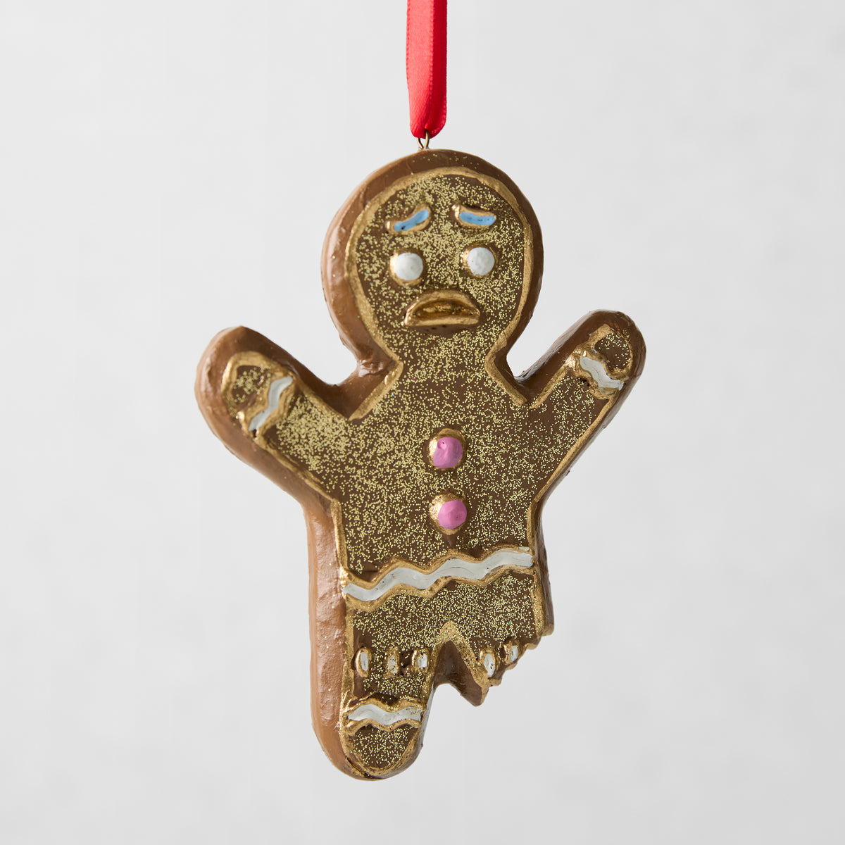 4.5-inch gingerbread man Christmas ornament made of hand-painted glass and resin with glitter and icing details.