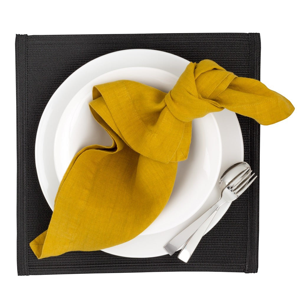 Gio Ponti Stainless Steel 5-piece flatware set with mirror finish, fork and spoon, on white plate with yellow napkin.