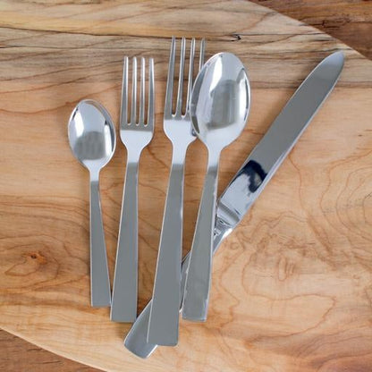 Gio Ponti 5-piece flatware set: mirror-finish 18/10 stainless steel fork, knife, spoons on wood.
