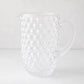 Clear glass pitcher with textured bubble design, handle, and pouring spout.