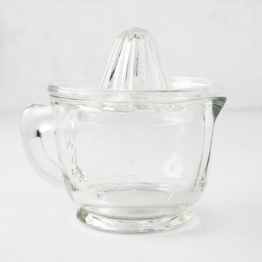 Clear recycled glass juicer with ribbed cone, handle, spout, and engraved measurements.