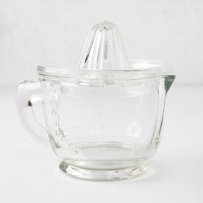 Clear recycled glass juicer with ribbed cone, handle, spout, and engraved measurements.
