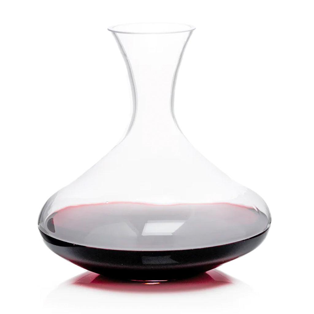 Clear mouth-blown glass wine carafe with a broad base and curved neck, partially filled with red wine.