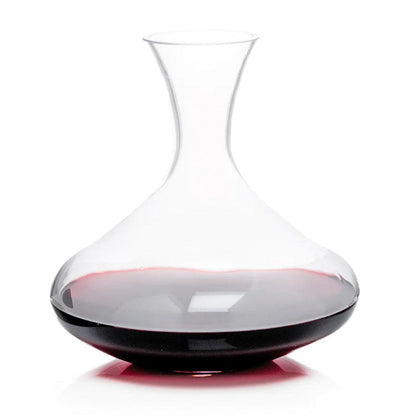 Clear mouth-blown glass wine carafe with a broad base and curved neck, partially filled with red wine.