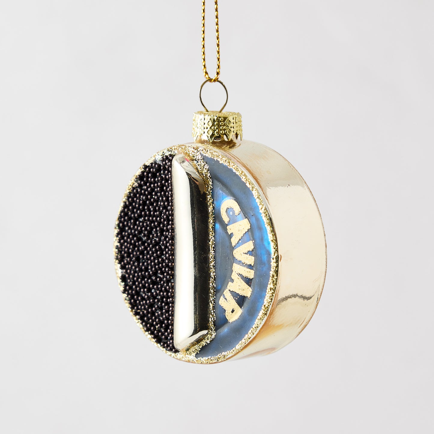 3.25-inch round glass ornament with gold finish, black caviar-textured detail, and Caviar lettering.