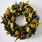 Golden Dawn Wreath with magnolia leaves, blue juniper, canella berries, rosehips, and golden yarrow.