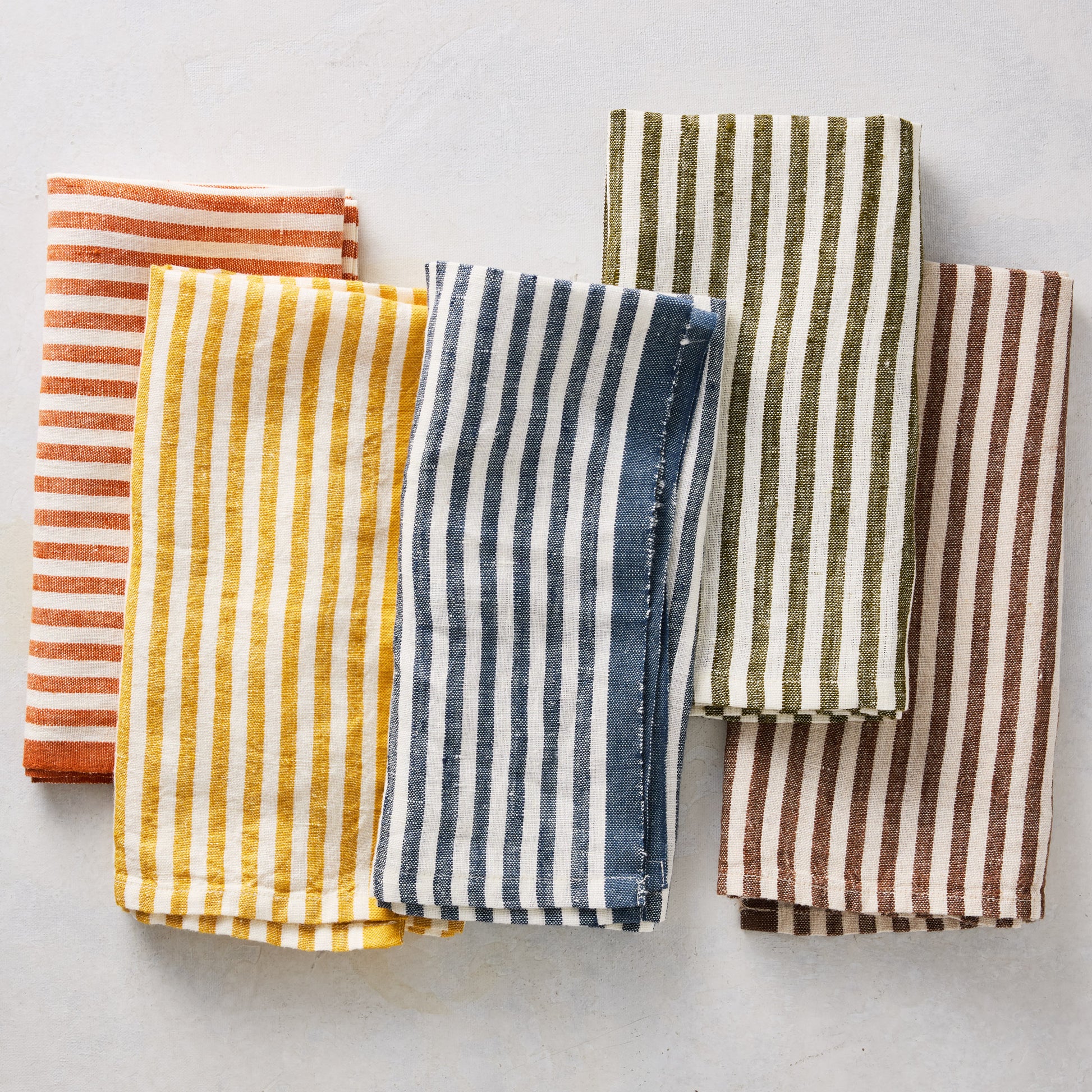 Set of five 21-inch square cotton napkins featuring multi-colored ticking stripes on a white base.