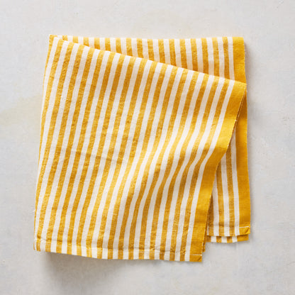 21-inch square cotton napkin with golden yellow and white ticking stripes and a yellow border.