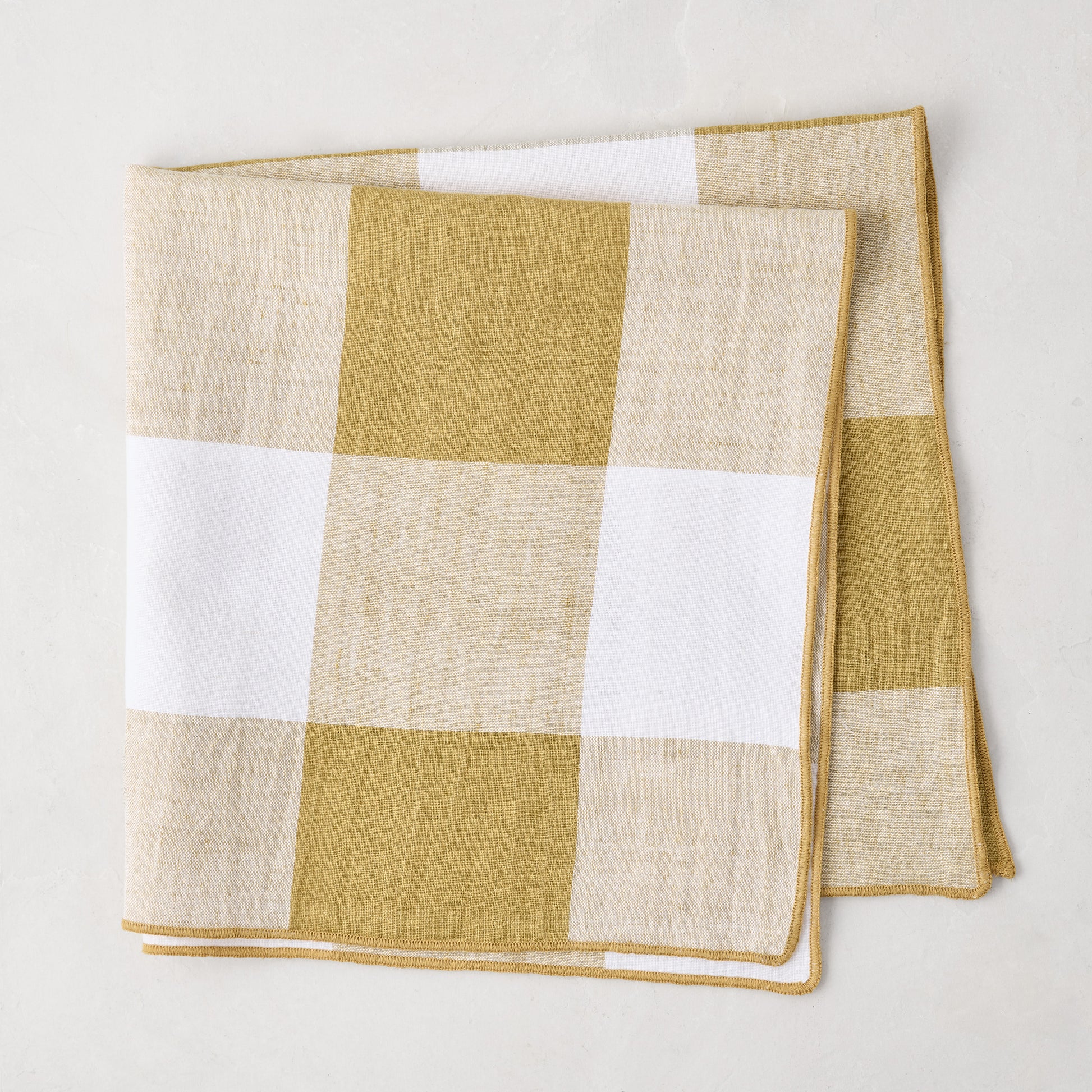 Goldenrod Buffalo Check Linen Napkin, 20" x 20", folded, with gold yellow and white squares.