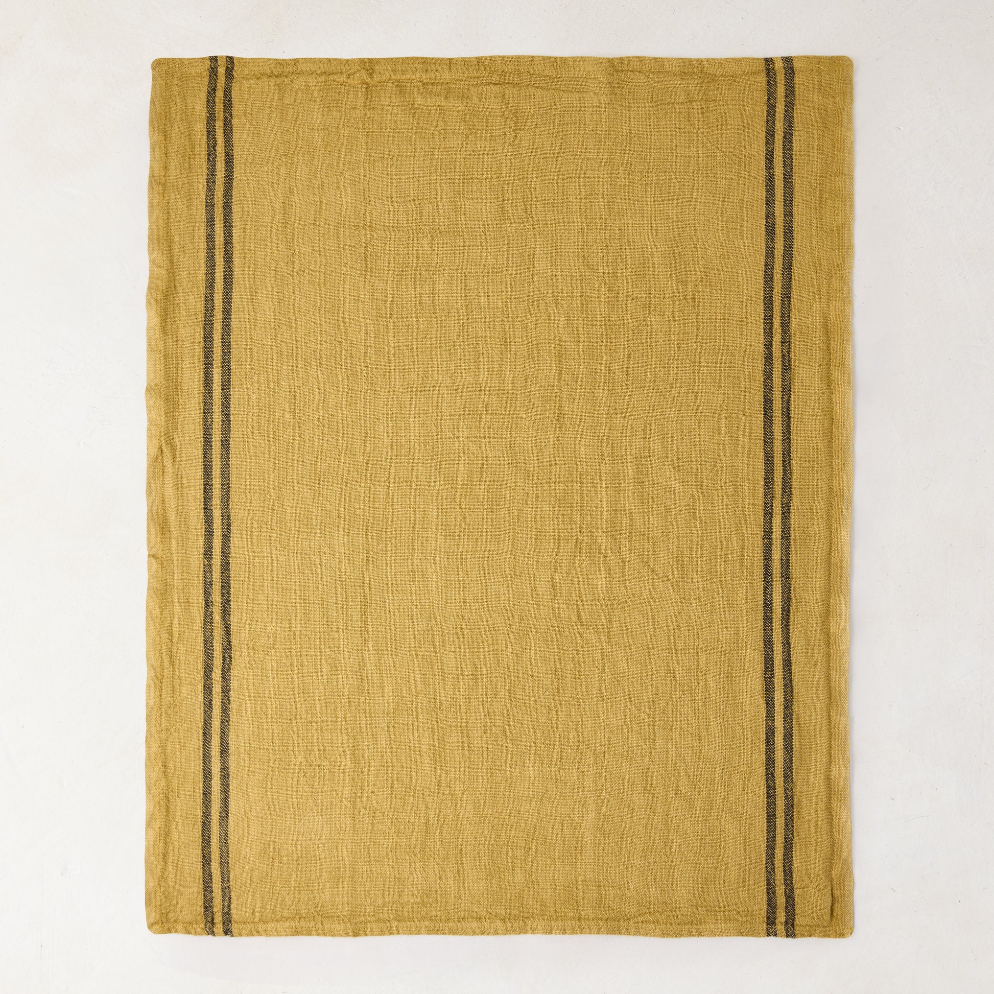 Goldenrod yellow French linen tea towel with two vertical dark gray stripes on each side.