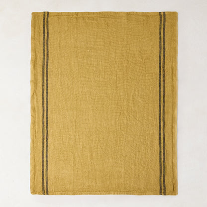 Goldenrod yellow French linen tea towel with two vertical dark gray stripes on each side.