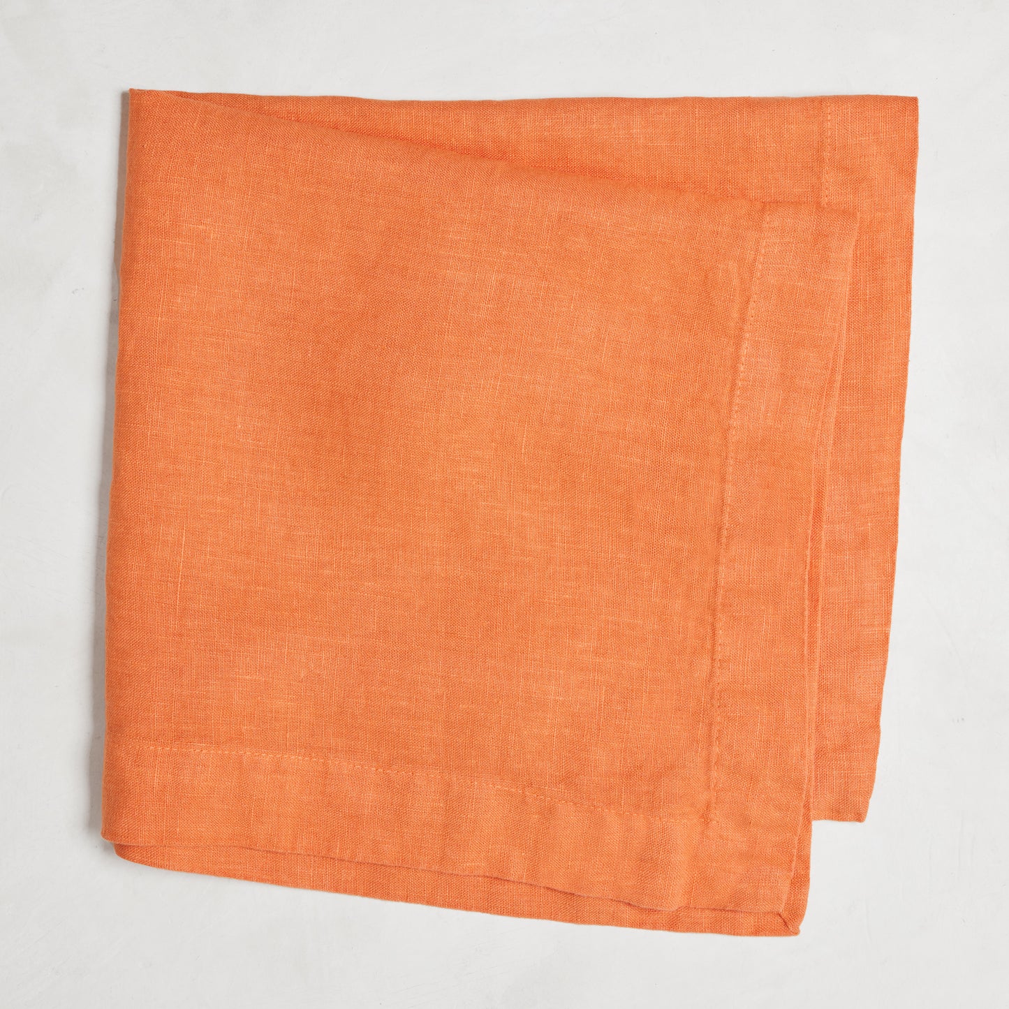 Goldfish HG Signature hand-dyed linen napkin, folded, with mitered corners.