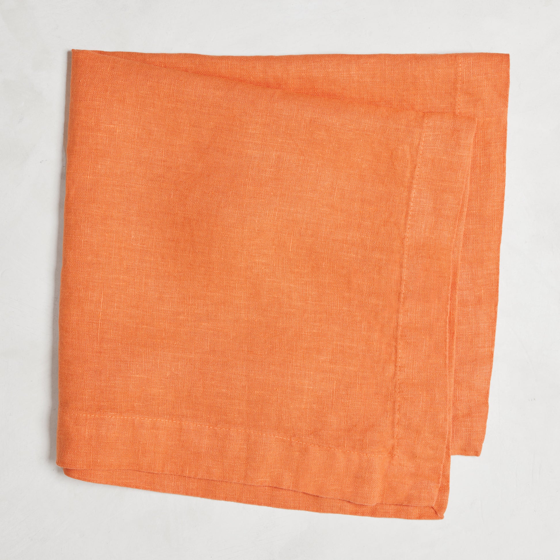 Goldfish HG Signature hand-dyed linen napkin, folded, with mitered corners.