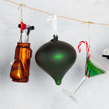 6-inch mouth-blown glass golf bag ornament with glittered details and miniature clubs hanging on a string.