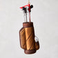 6-inch glass and resin golf bag Christmas ornament with miniature clubs, a red flag, and glittered bronze finish.