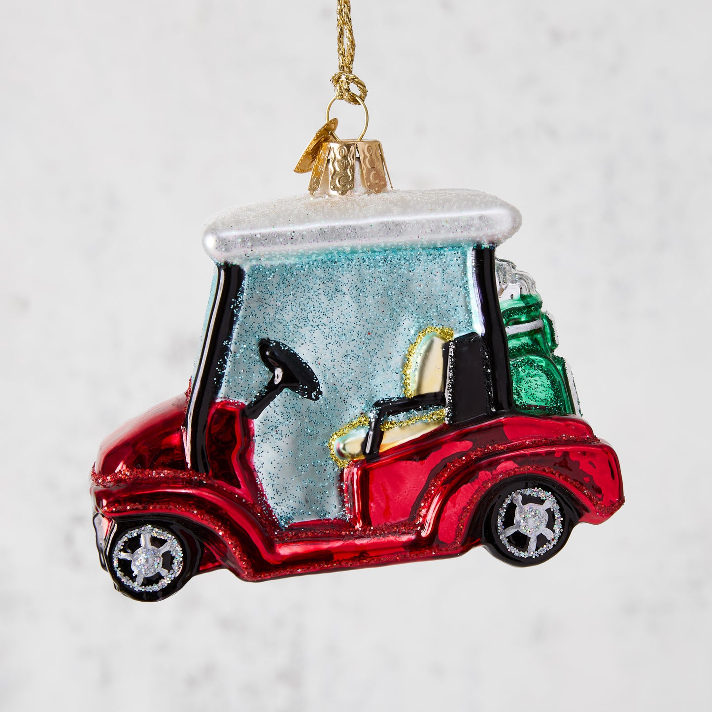 Red glitter glass golf cart Christmas ornament with clubs.