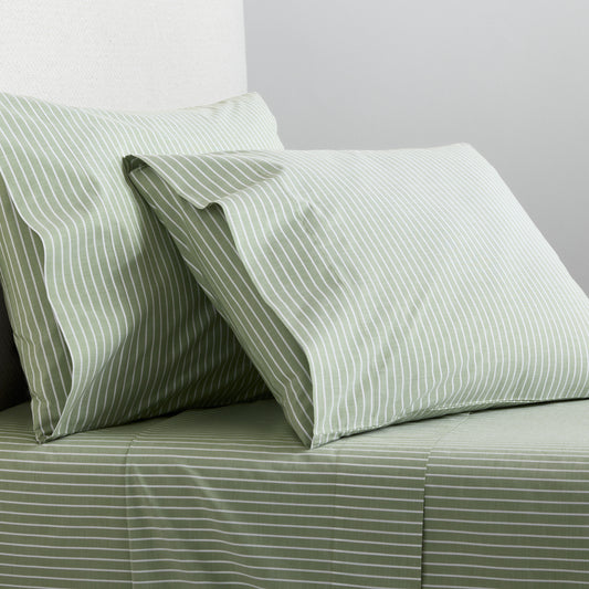 Green and white striped percale sheet set with matching pillowcases on a bed.