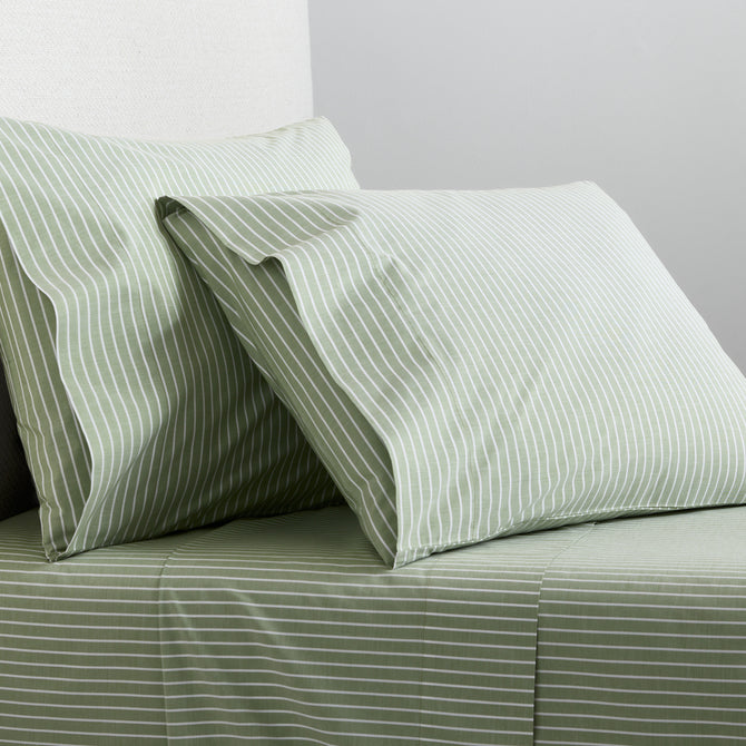 Green and white striped percale sheet set with matching pillowcases on a bed.
