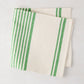 Folded green boat stripe napkin, 22" square, cotton-linen blend.