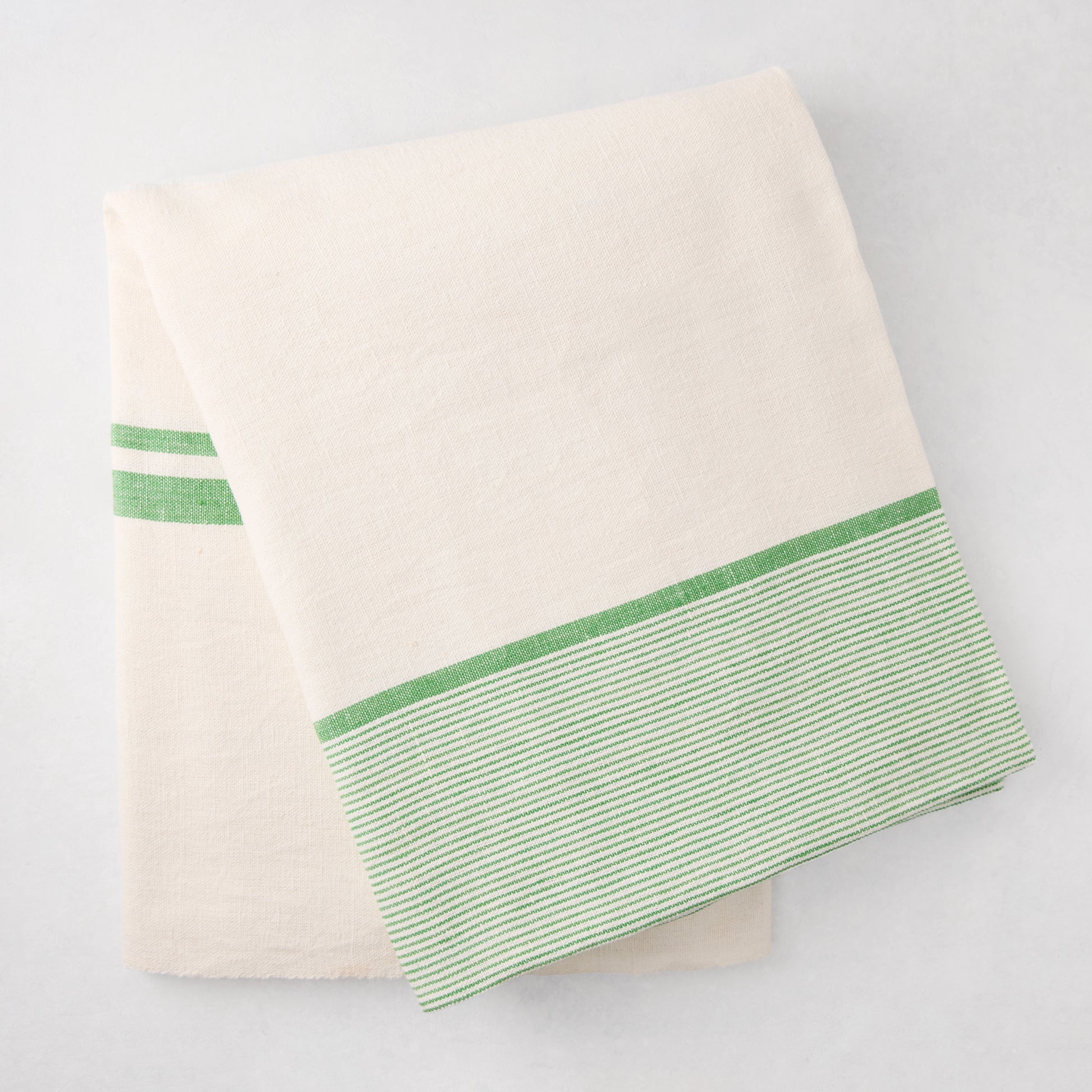 Folded Green Boat Stripe Tablecloth, 70"x108" cotton-linen blend, with green striped border.